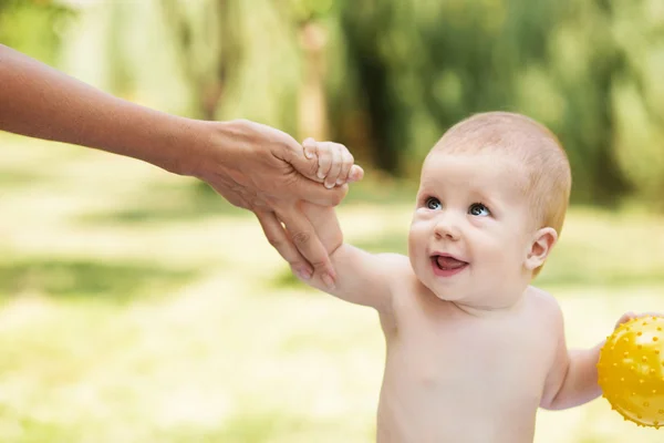 Portrait of a beautiful baby holding the mother's hand — Stock Photo, Image