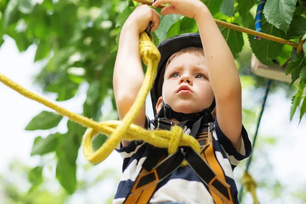 Pojke har klättring i rep kurs äventyr. ler barn — Stockfoto