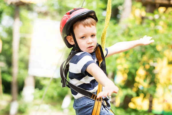 Kids climbing in adventure park. Boy enjoys climbing in the rope — Stock Photo, Image