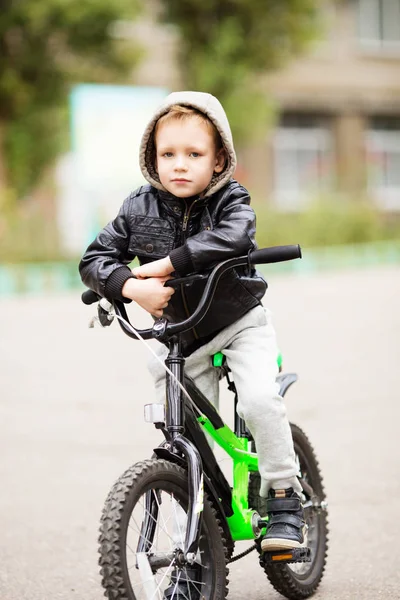 The boy learns to ride a bike.