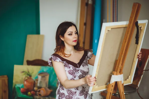 Woman artist painting a picture in a studio — Stock Photo, Image