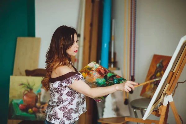 Artista mujer pintando un cuadro en un estudio — Foto de Stock