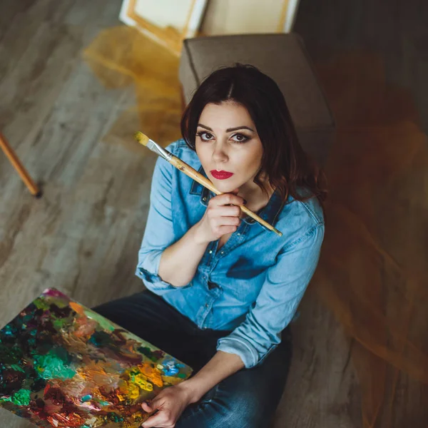 Woman artist painting a picture in a studio — Stock Photo, Image