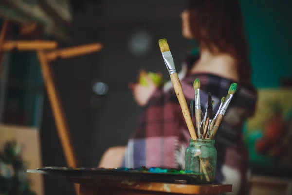 Primo piano di pennelli pittura sullo sfondo di una donna ar — Foto Stock