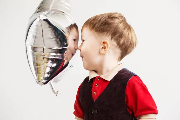 Chłopiec grymasy i gra małpa z balony w kształcie gwiazdy — Zdjęcie stockowe