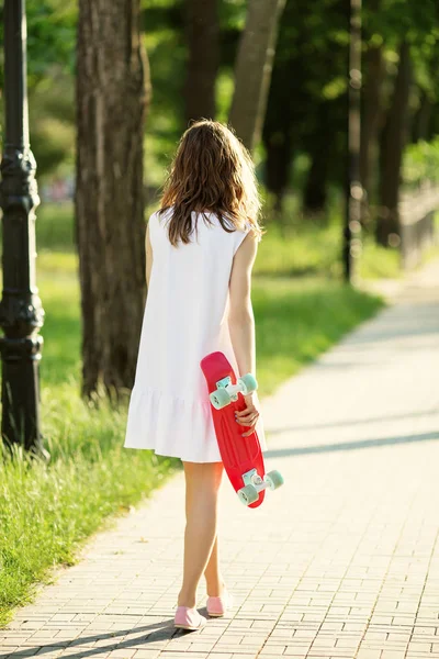 Girl holding a plastic skate board outdoors — Stock Photo, Image