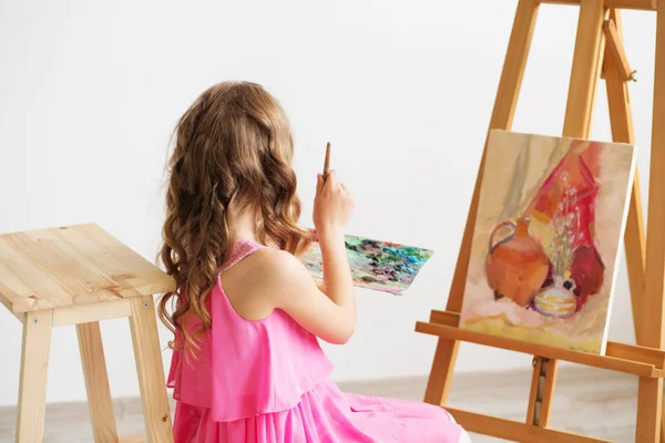 Портрет милой маленькой девочки, рисующей картину в студии — стоковое фото