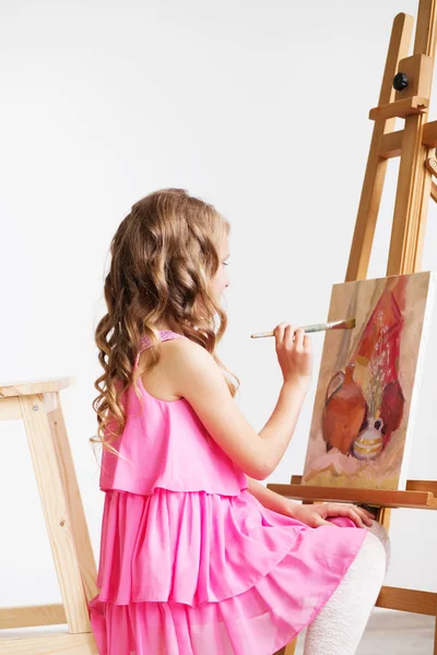 Retrato de uma linda menina pintando um quadro em um estúdio — Fotografia de Stock