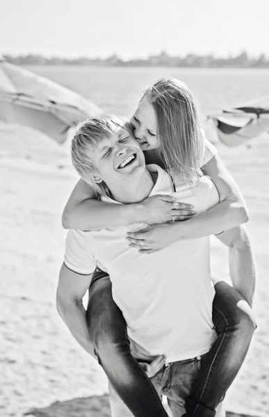 Jovem casal apaixonado se divertindo e pulando na praia — Fotografia de Stock