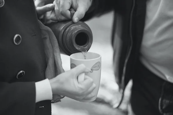 Paar gießt Tee aus Thermoskanne in die Tasse zum Aufwärmen — Stockfoto