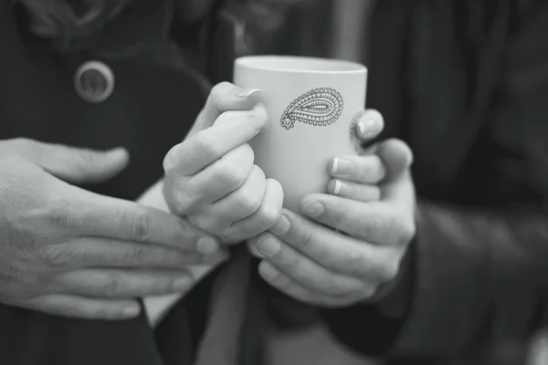 Couple warming his hands on a cup of hot tea — Stock Photo, Image