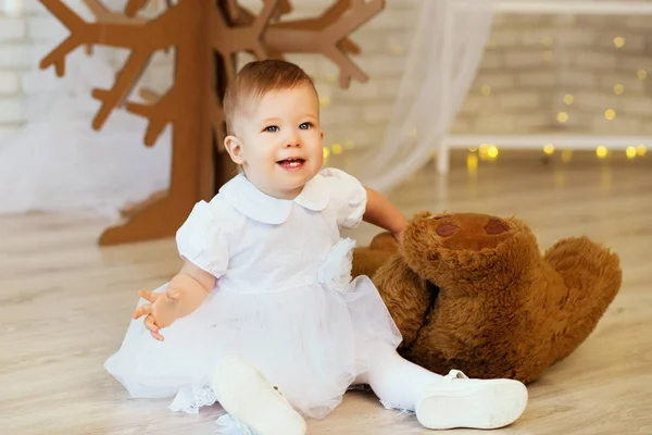 Menina com um urso de pelúcia marrom macio no interior com Chri — Fotografia de Stock