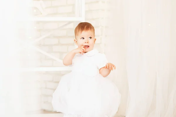 Schöne kleine Mädchen in einem weißen Kleid im Inneren mit Christus — Stockfoto