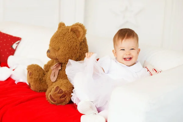 Retrato de uma linda menina com um urso de pelúcia marrom macio i — Fotografia de Stock