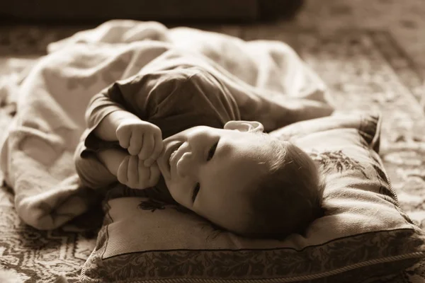 Feliz bebê rindo deitado em uma cama — Fotografia de Stock