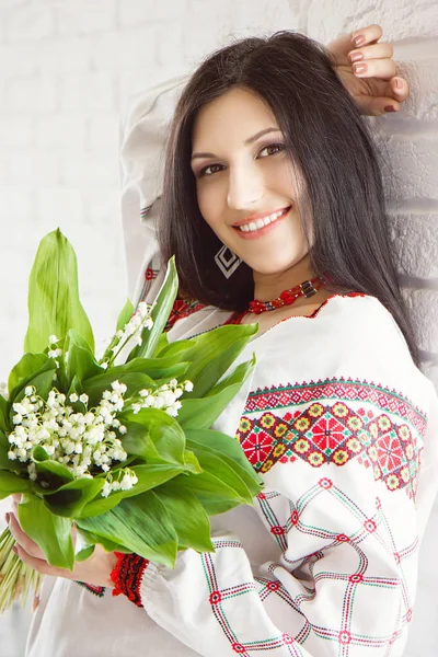 Vackra ukrainska flicka i nationella klänning med bukett av blo — Stockfoto