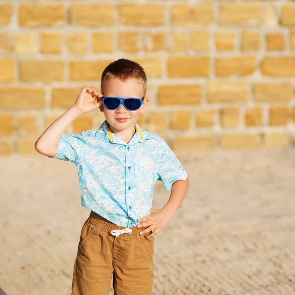 Little boy wearing blue mirror sunglasses against the yellow bri — Stock Photo, Image