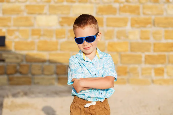 Kleiner Junge mit blauer Spiegelsonnenbrille gegen den gelben BH — Stockfoto
