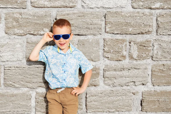 Kleiner Junge mit blauer Spiegelsonnenbrille gegen den gelben BH — Stockfoto