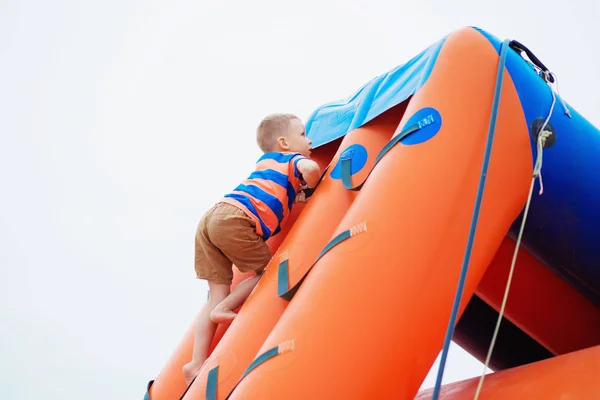 Kleine jongen spelen op een opblaasbare speeltuin op het strand — Stockfoto