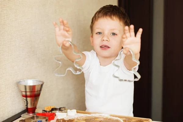 Le mani da bambini fanno il pan di zenzero. Ragazzino taglio biscotti per — Foto Stock