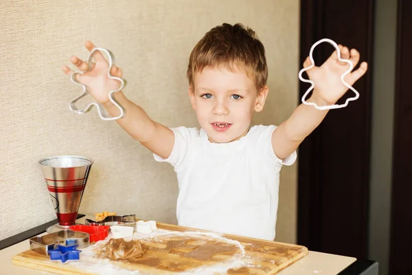 Barnens händer gör pepparkakor. Liten pojke skära cookies för — Stockfoto