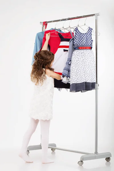Wanita kecil mencoba pakaian baru pada latar belakang putih . — Stok Foto