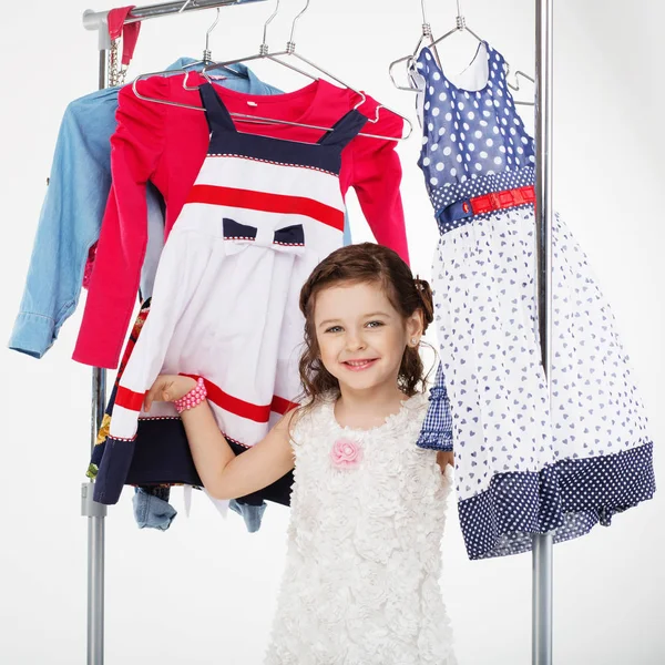 Mała dziewczynka i wieszaki na ubrania zakupy — Zdjęcie stockowe