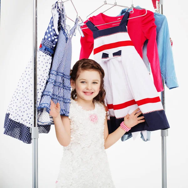 Маленька дівчинка і вішалки для одягу покупки — стокове фото