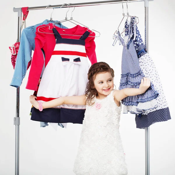 Little girl and clothes hangers shopping — Stock Photo, Image