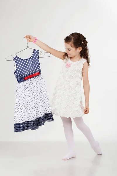 Little girl and clothes hangers shopping — Stock Photo, Image