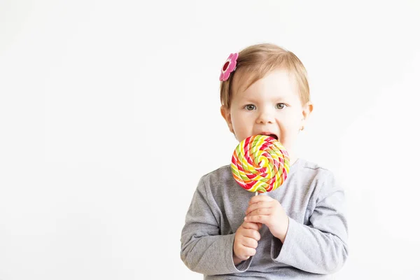 Ragazzina che mangia lecca-lecca. Bambini felici con un grande delizioso — Foto Stock