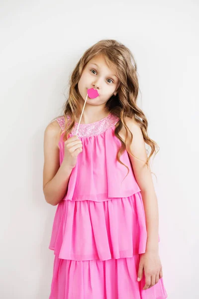 小女孩用滑稽的粉红色纸嘴唇对白色的背景 — 图库照片