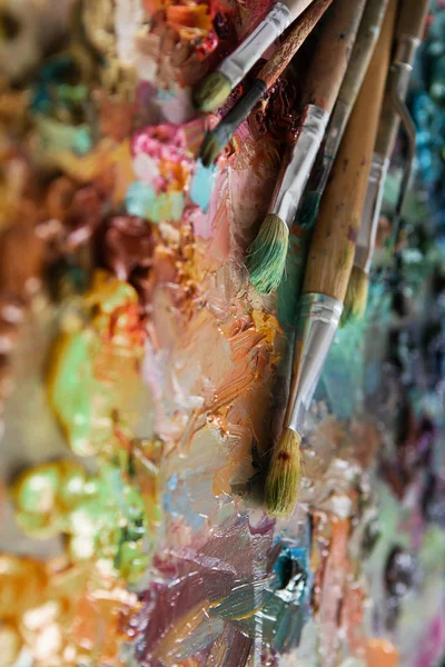 Pinceles y pinturas al óleo sobre paleta de madera — Foto de Stock