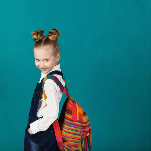 Belle petite fille souriante avec un grand sac à dos debout contre — Photo