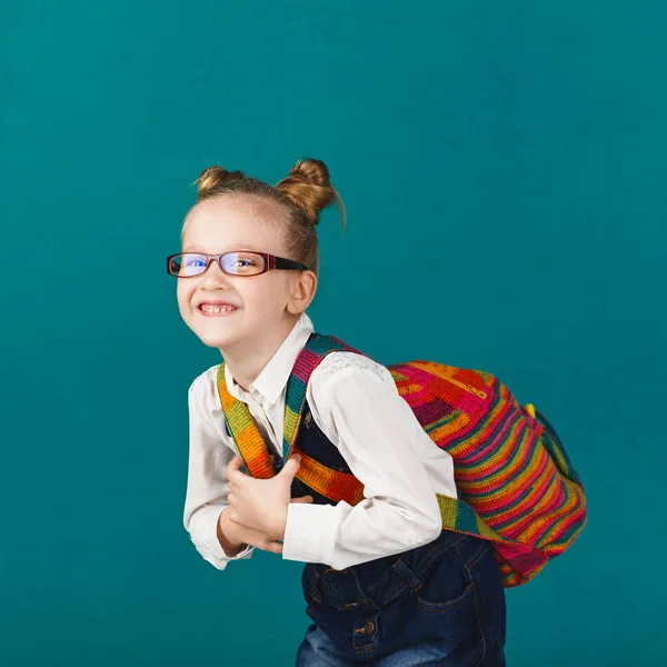 Rolig leende liten flicka med stor ryggsäck hoppning och har f — Stockfoto