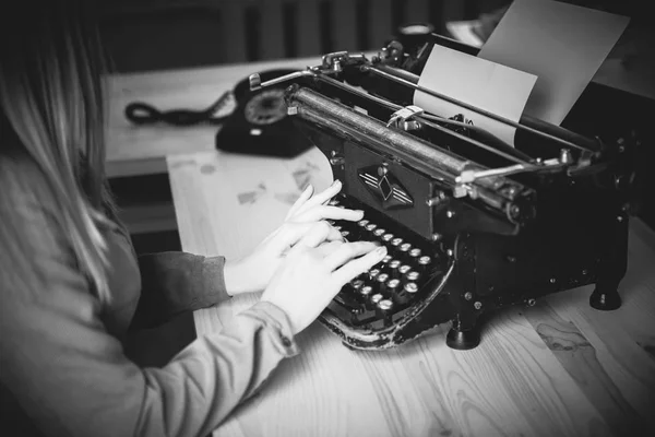 Secretaria en la vieja máquina de escribir con teléfono. Mujer joven usando ty — Foto de Stock