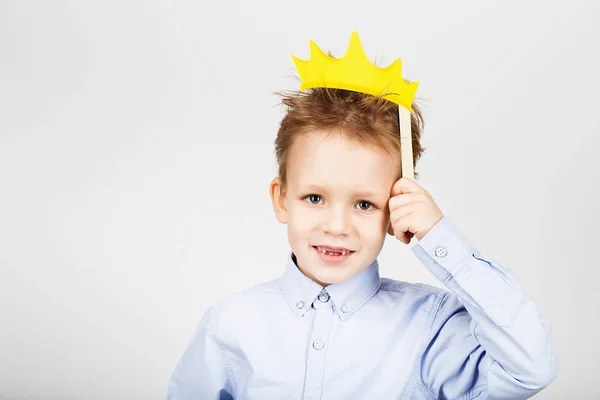 Retrato de um menino bonito escola com papel amarelo coroa aga — Fotografia de Stock