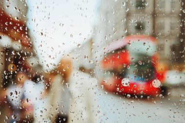 Arka plan cam ve kırmızı Londra otobüs üzerinde yağmur damlası ışıklar.