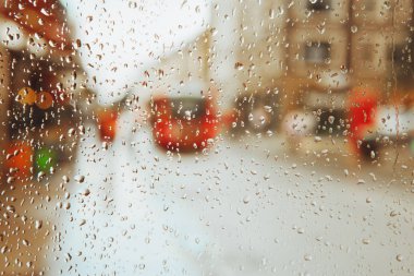 Bulanık arka plan cam ve kırmızı Londra otobüs üzerinde yağmur damlası ışıklar. 