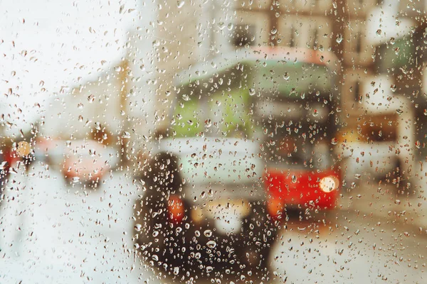 Raindrop su vetro e luci rosse degli autobus di Londra — Foto Stock