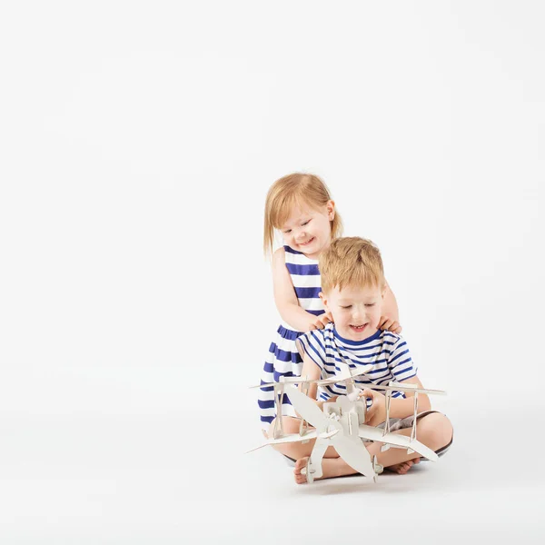 Crianças brincando com papel brinquedo avião sentado no f — Fotografia de Stock