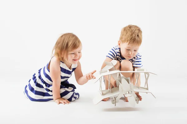 Anak-anak kecil bermain dengan mainan pesawat kertas duduk di f — Stok Foto