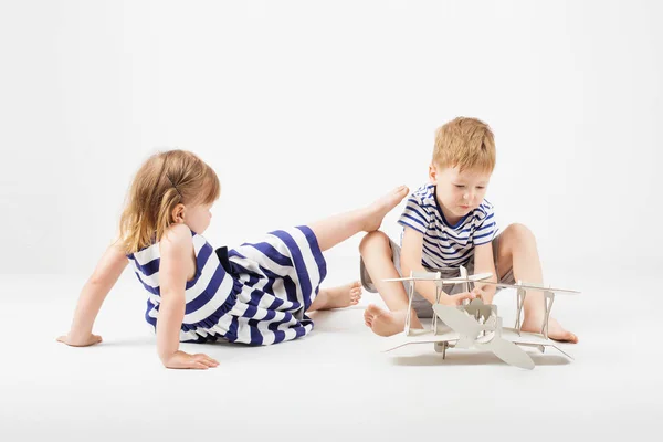 Crianças brincando com papel brinquedo avião sentado no f — Fotografia de Stock