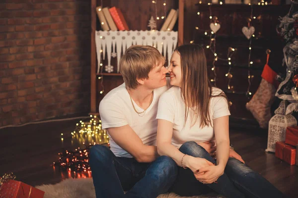 Belo casal apaixonado jazia no chão no Natal . — Fotografia de Stock