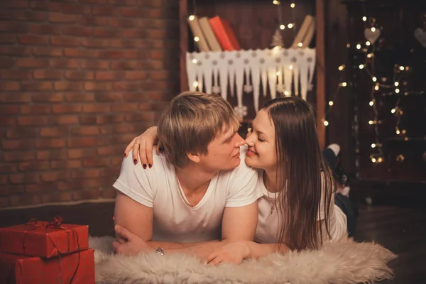 Belo casal apaixonado jazia no chão no Natal — Fotografia de Stock