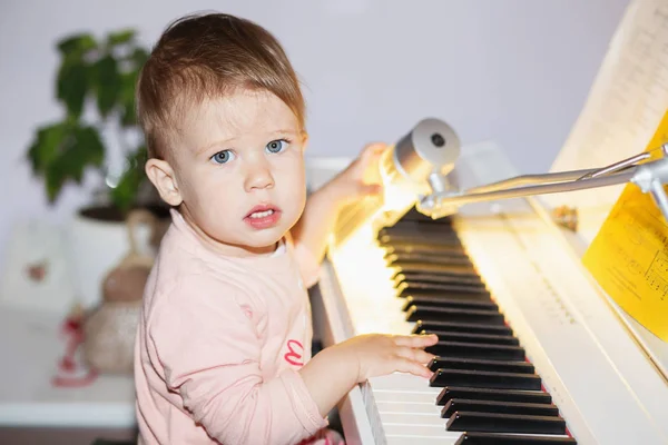 Liten flicka åtnjuter spelar elpiano (synthesizer) för f — Stockfoto