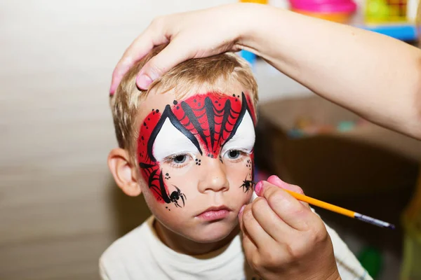 男の子の顔にアクア化粧を作るマスター ハロウィーン パーティー 顔絵画子供 — ストック写真