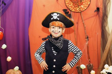 Cadılar Bayramı partisi. Bir korsan kostüm ve makyaj yüzünde küçük bir çocuk Cadılar Bayramı partisinde iyi bir dönemden geçiyor. Yüz boyama çocuklar. Çocuk halloween süslemeleri arasında