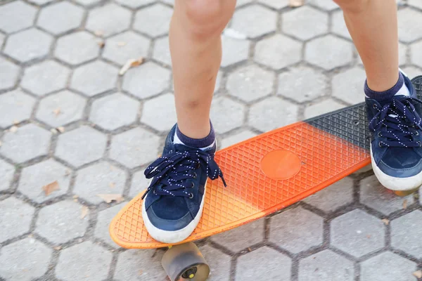 Rapaz urbano com um skate de um centavo. Jovem criança equitação em th — Fotografia de Stock